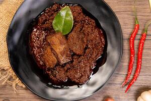 Beef Rendang is a Minang dish originating from the Minangkabau region in West Sumatra, Indonesia. Rendang has been slow cooked and braised in a coconut milk seasoned with a herb and spice mixture photo