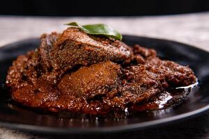 Beef Rendang is a Minang dish originating from the Minangkabau region in West Sumatra, Indonesia. Rendang has been slow cooked and braised in a coconut milk seasoned with a herb and spice mixture photo