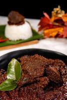 Beef Rendang is a Minang dish originating from the Minangkabau region in West Sumatra, Indonesia. Rendang has been slow cooked and braised in a coconut milk seasoned with a herb and spice mixture photo