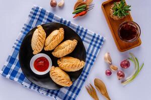Curry puff or Pastel goreng. it is a small pie consisting of curry with chicken and potatoes in a deep fried or baked pastry shell photo