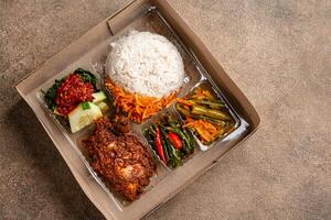 In Indonesian it is called Rice Box or Nasi kotak with ayam rendang. Usually distributed during celebrations or catering packaging. photo