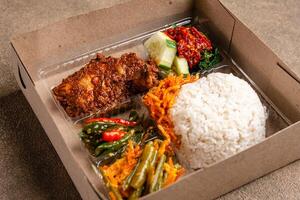 In Indonesian it is called Rice Box or Nasi kotak with ayam rendang. Usually distributed during celebrations or catering packaging. photo