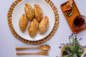 Curry puff or Pastel goreng. it is a small pie consisting of curry with chicken and potatoes in a deep fried or baked pastry shell photo