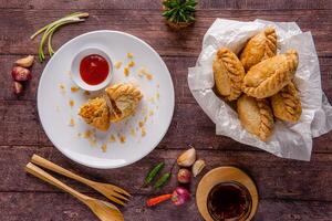 Curry puff or Pastel goreng. it is a small pie consisting of curry with chicken and potatoes in a deep fried or baked pastry shell photo