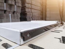 Close up of the paper cutter with a background of a pile of brown cardboard and shiny light. photo