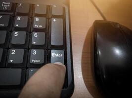 The finger push on the Enter key on the keyboard , Aprove data concept. photo