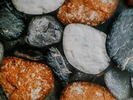 photo shows smooth, rounded stones arranged in a mosaic. The stones vary in color and texture.