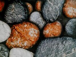 photo shows smooth, rounded stones arranged in a mosaic. The stones vary in color and texture.