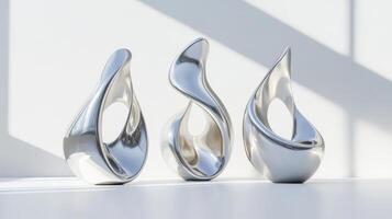 A trio of abstract chrome sculptures with fluid, reflective surfaces, displayed in a brightly lit minimalist interior. photo