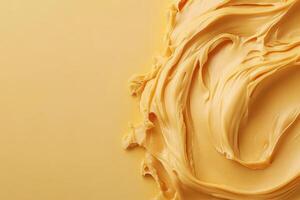 Swirling creamy peanut butter on a warm yellow background photo