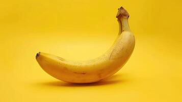 A Single Banana Curved on a Vibrant Yellow Background photo