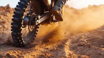 a dirt bike tire throwing up sand. photo