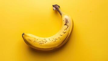 A Single Ripe Banana On A Vibrant Yellow Background photo