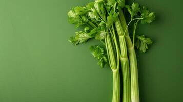 Fresh Green Celery Stalks Against a Vibrant Green Background photo