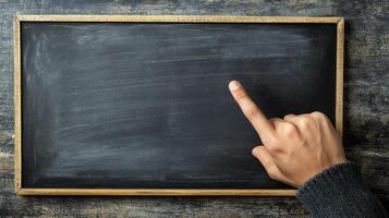 Educator pointing at a blank blackboard with a symbolic gesture. photo