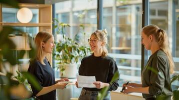 A Bright Conversation Amidst Greenery Three Women Collaborate in a Modern Office Space photo