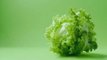 A Single Head of Crisp Green Lettuce Rests on a Vibrant Green Background photo