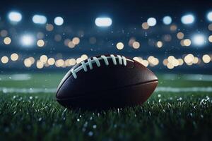 A lone football rests on the field under stadium lights photo