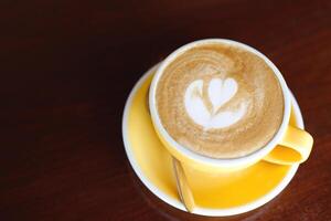 hot coffee cup latte art with spoon Serve ready to drink in cafe on wooden table coffee shop. Leave copy space empty to write the side text. soft focus. photo