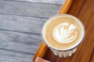 hot coffee cup latte art with spoon Serve ready to drink in cafe on wooden table coffee shop. Leave copy space empty to write the side text. soft focus. photo