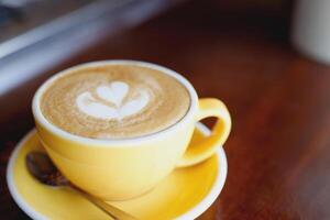 hot coffee cup latte art with spoon Serve ready to drink in cafe on wooden table coffee shop. Leave copy space empty to write the side text. soft focus. photo