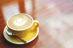 hot coffee cup latte art with spoon Serve ready to drink in cafe on wooden table coffee shop. Leave copy space empty to write the side text. soft focus. photo