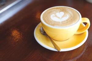 hot coffee cup latte art with spoon Serve ready to drink in cafe on wooden table coffee shop. Leave copy space empty to write the side text. soft focus. photo