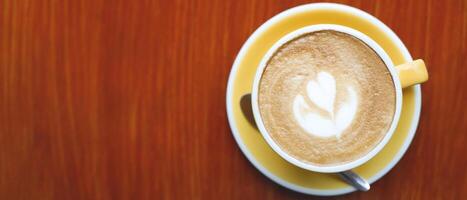 hot coffee cup latte art with spoon Serve ready to drink in cafe on wooden table coffee shop. Leave copy space empty to write the side text. soft focus. photo