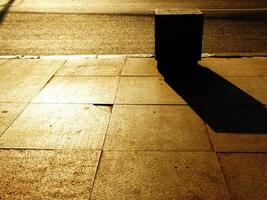 A sidewalk with a shadow of a stone box on it. Copy space for text photo