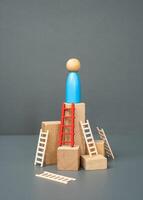The man reached the top with the help of the red ladder. The concept of choosing the right way and tool to achieve success. Go through difficulties. Reach the pinnacle of mastery. photo