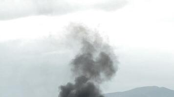 Big column of black smoke from a fire going up in the sky video