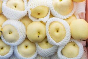Fresh Yellow Pears Wrapped in Mesh Netting photo