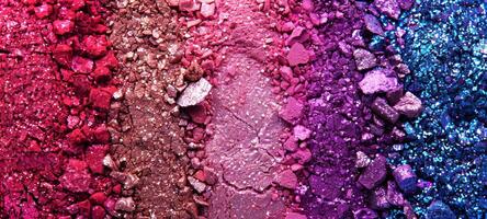 A close-up top view of crushed pink and purple eyeshadow powders, creating a vibrant texture and color gradient. Concept of beauty products, cosmetics, and makeup artistry. Background, banner photo