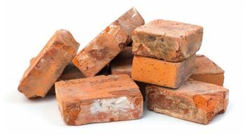 Stack of rustic red bricks in disarray on a white background. Concept of construction materials, building foundation, masonry work, home improvement photo