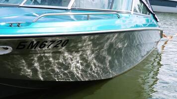 Sunlight reflecting on a moored boat hull, creating a mesmerizing play of light and water. Minsk, Belarus - July 7, 2024 video