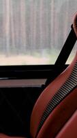 Red leather and fabric bus seat with safety belt visible approaching a destination in slow motion video