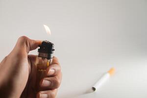 A person holding a lighter and a cigarette photo