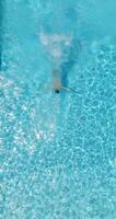 aéreo Visão Como uma homem mergulhos para dentro a piscina e nada, lento movimento video