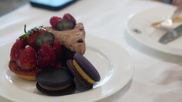 close up to set of sweet dessert cake and macaroon while using hand to grab macaroon to eat in afternoon tea time video