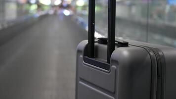 pov with selective focusing to luggage handle handheld on the moving escalator walkway while in airport departure terminal hall moving to departure gate video