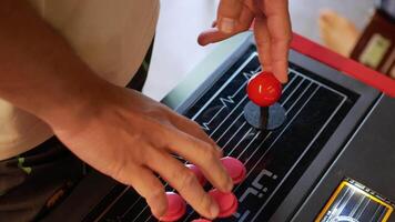 view to man's hands while holding game conrtrol panel for playing 70's game console in arcade video
