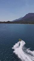 Aerial drone top view tracking of yellow speed boat cruising and having fun while making curves in high speed deep video