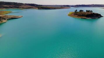 Capturing an aerial view over a serene turquoise lake surrounded by scenic islands and lush landscape. Perfect for nature and travel visuals video