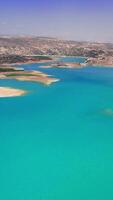 turquesa águas espelho uma Claro azul céu dentro verão, enquanto retrocedendo água níveis revelar ressecado terra por aí a lago, exibindo a impactos do seca e clima mudança video