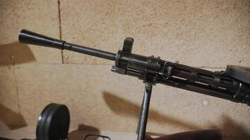 Light machine gun on bipod with drum magazine, military weapon video