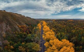 Aerial view of road in beautiful autumn Altai forest photo