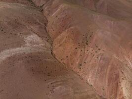 Aerial shot of the textured yellow nad red mountains resembling the surface of Mars photo