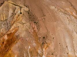 Aerial shot of the textured yellow nad red mountains resembling the surface of Mars photo