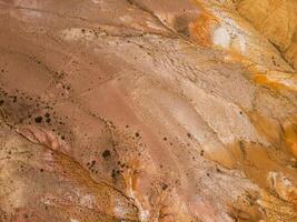 Aerial shot of the textured yellow nad red mountains resembling the surface of Mars photo