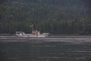 Ship with russian flag on the Teletskoye lake in Altai mountains photo